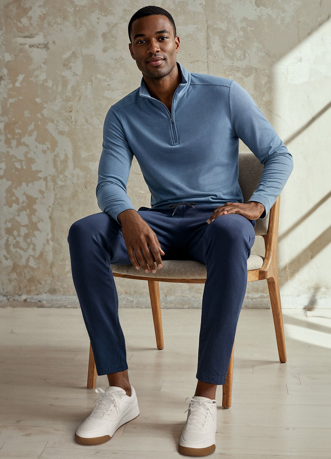 man on chair skechers shoes